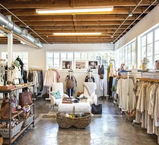 A daylit boutique with rails of clothing and a central seating island